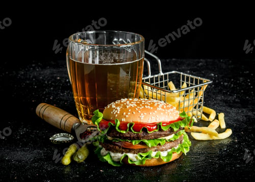 Preview: Burger with beer, fries and gherkins.