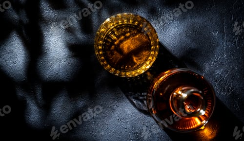 Preview: Whiskey, scotch or bourbon in glass and bottle, black stone background with hard light