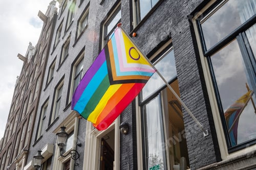 Preview: Progress Pride flag displayed on the exterior of a historic building