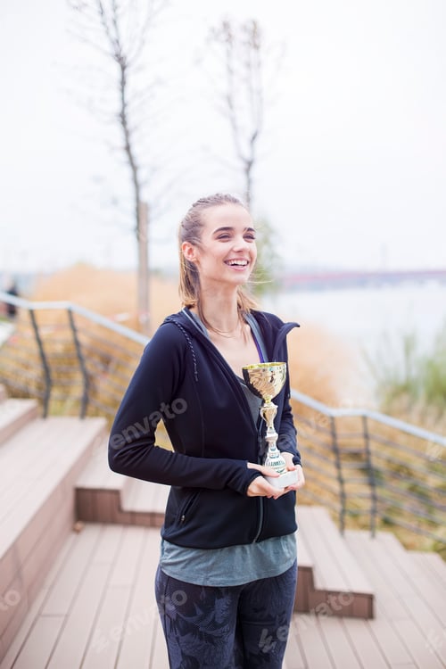 Preview: Sport woman holding a trophy