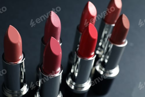 Preview: Set of different lipsticks on grey background, closeup. Cosmetic product
