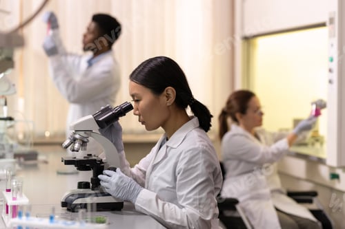 Preview: Chinese female scientist looking in microscope