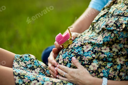 Preview: Unrecognizable couple, future parents, pregnant young woman and a man touching belly