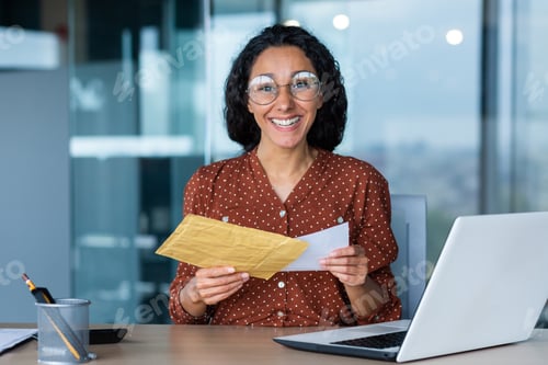 Preview: Happy hispanic woman smiling and looking at camera, business woman received envelope with good news