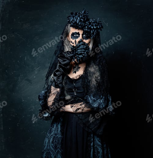 Preview: portrait of a girl in a witch costume with black flowers on a dark background.