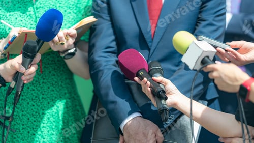 Preview: Journalists with microphones gather at a press conference