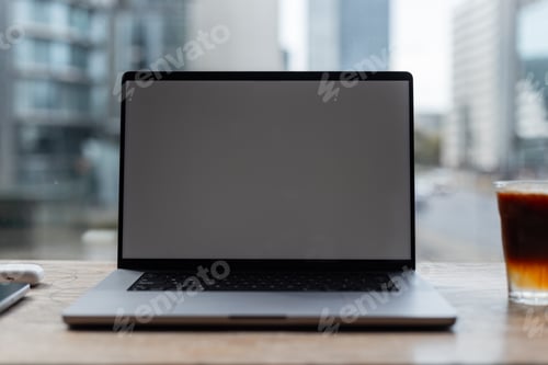 Preview: Laptop mockup display stands on vintage wooden table in office on urban background