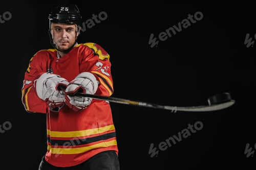 Preview: professional hockey player holding hockey stick isolated on black