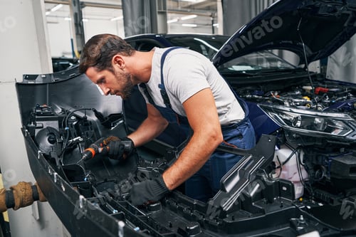 Preview: Automobile mechanic using drill on car part