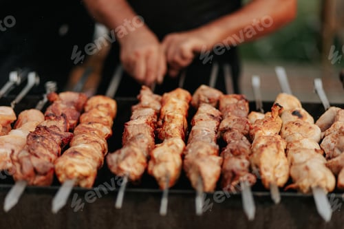 Preview: Frying shish kebab on the skewers in brazier. Fresh ruddy meat for barbecue grill on fire outdoor.