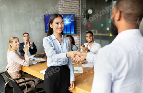Preview: Black Boss Shaking Hands And Congratulating Asian Female Employee With Business Success
