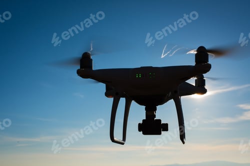 Preview: White drone hovering in a bright blue sky