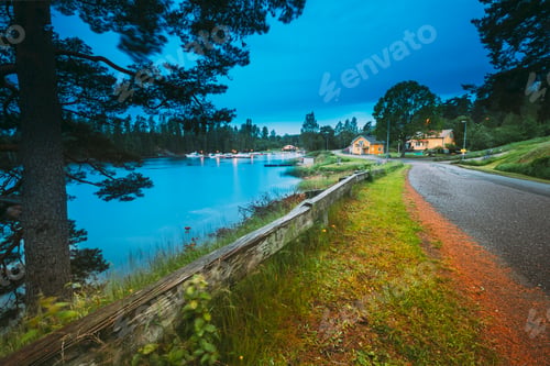 Preview: Sweden. Road To Beautiful Swedish Village near Lake. Wooden Log Cabin Houses In Summer Evening Night