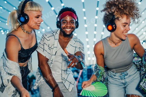 Preview: Friends enjoying music festival with wireless headphones
