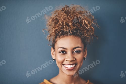 Preview: Smiling Woman with Curly Hair in Studio Setting