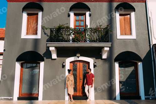Aperçu: Portrait of a full length stylish bearded man and his wife standing near the building
