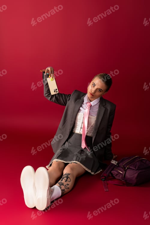 Preview: Stylish young woman in a chic outfit poses confidently against a bold red background