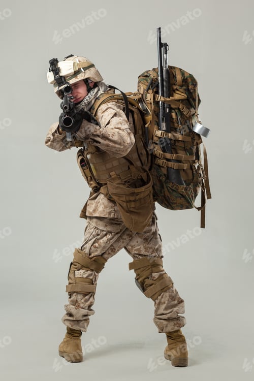 Preview: Soldier in tactical gear aiming weapon with backpack on a neutral background