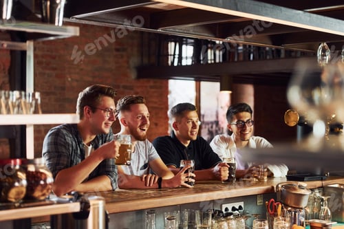 Preview: People in casual clothes sitting in the pub and drinking beer