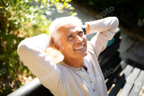Preview: Close up handsome older man relaxing in park with hands behind head