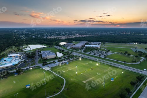 Preview: Aerial view of public sports park with people engaged in football game