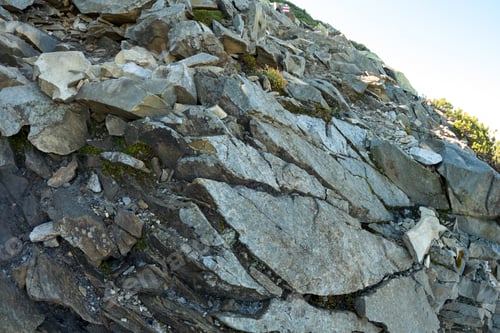 Preview: Rocky mountain hillside with big stone boulders on sunny day