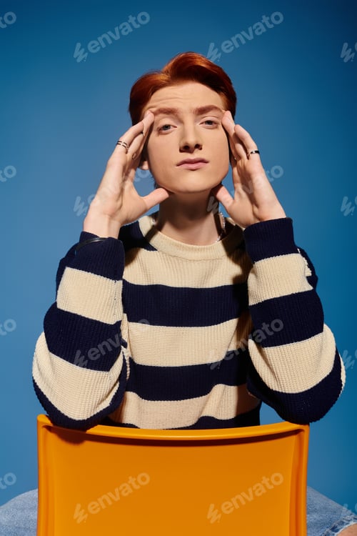 Preview: Emotional young man expressing thoughts against a vibrant blue backdrop