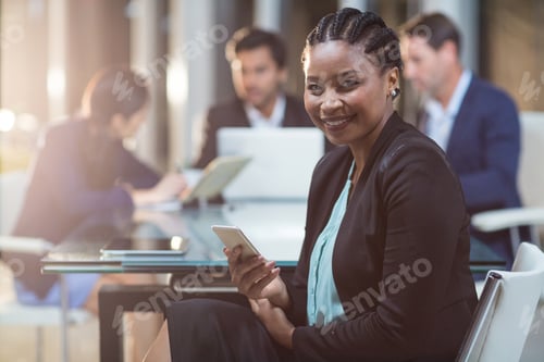 Preview: Portrait Of Businesswoman Holding Mobile Phone In The Office