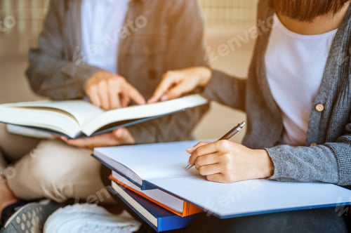 Preview: Two students are sitting at the stairs reading books to education and using laptop. Study for test p