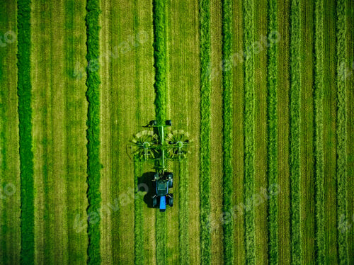 Preview: Aerial view of Tractor mowing green field in Finland.