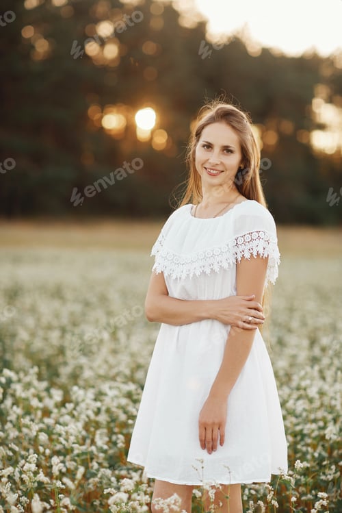 Preview: Portrait of a beautiful girl in a white dress in a flowering field. Field of flowers. Summer. unity