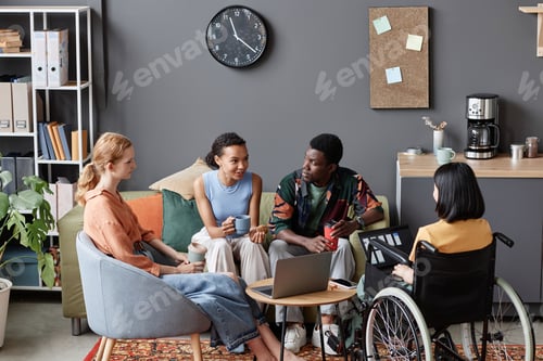 Preview: Diverse group of young professionals meeting in office lounge