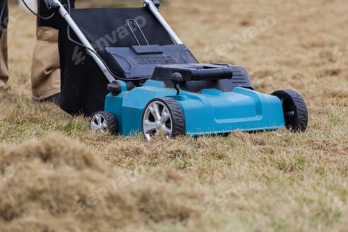 Preview: Scarifying lawn with scarifier, Man gardener scarifies the lawn and removal of old grass