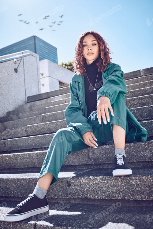 Preview: Fashion, style and city with a model black woman sitting on stairs outside during a clear summer da