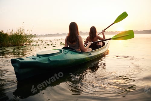 Preview: Rowing with oars. Women friends are on sup board on the lake together