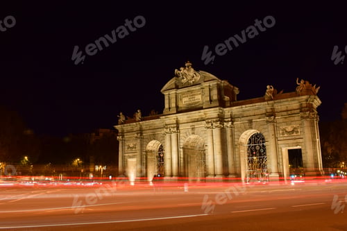 Preview: The Puerta de Alcala in Madrid at night. With flashes and lights of cars passing by.