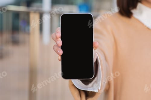 Preview: Millennial caucasian woman shows modern smartphone with blank screen, recommends app