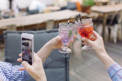 Woman Taking Picture of Toasting Colorful Drinks