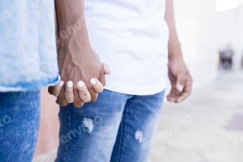 Preview: Close up of romantic couple holding hands while standing on street. Midsection of couple