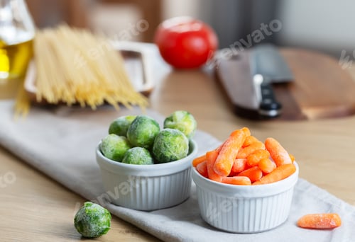 Preview: Frozen vegetables such as baby carrot and Brussels sprouts as well as dry pasta on the kitchen table