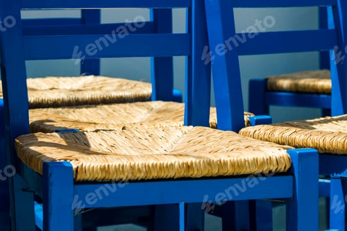 Preview: Traditional blue painted wooden chairs with Reed seating on an empty Greek terrace in Greece.