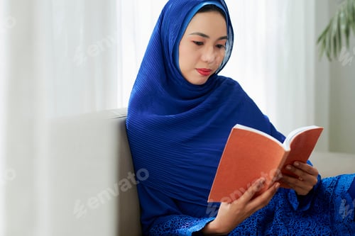 Preview: Asian woman in hijab reading book