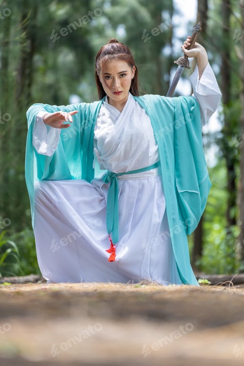 Preview: Young beautiful Asian woman dressed in ancient Chinese warrior style with ancient fan