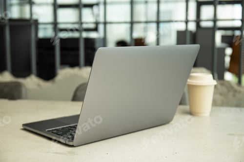 Preview: A cup of coffee on the table near the laptop close-up
