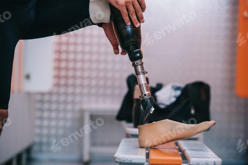Preview: cropped shot of sportsman putting on his artificial leg at changing room of gym