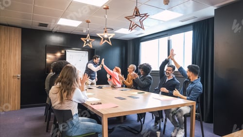 Preview: Businesspeople giving high-fives after a successful presentation in conference room