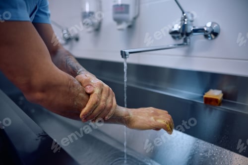 Preview: Close up of doctor washing hands while preparing for a surgery at the clinic.