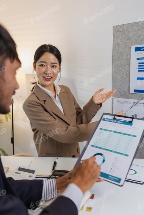 Preview: Business colleagues are actively engaged in a collaborative meeting, reviewing charts