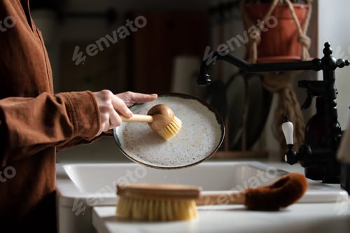 Preview: woman washes a plate in the kitchen using eco-friendly brushes