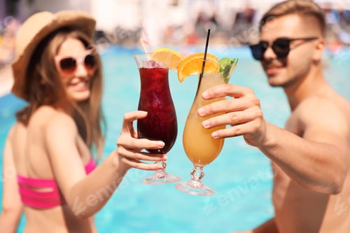 Preview: Young couple with cocktails near pool on sunny day, closeup